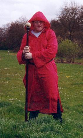 Chris Rouse playing Owen a mage.  He is wearing Red (Pink) robes and holds a staff with a white ball on the end.  